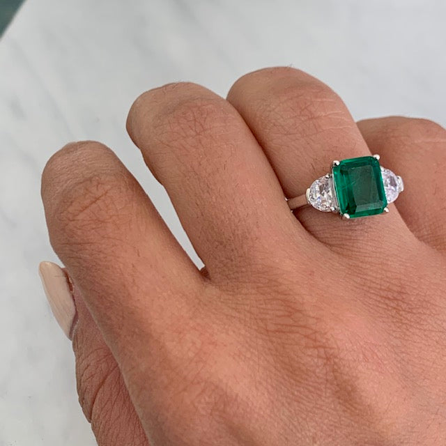 Emerald ring with side shop stones